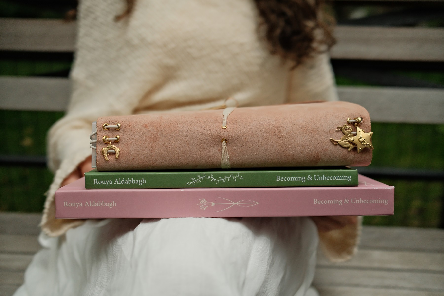 All three Becoming & Unbecoming books stacked: The Drift Realm, Love Letter, and the hand-bound leather journal
